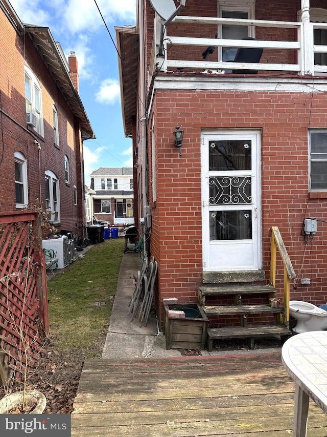 entrance to property with a deck and brick siding