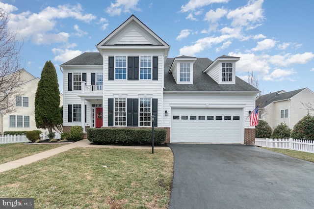 traditional home featuring fence, aphalt driveway, and brick siding