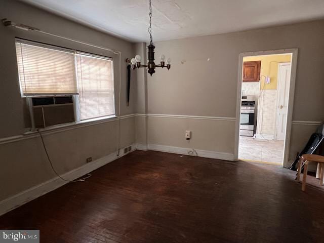 unfurnished dining area featuring cooling unit, an inviting chandelier, and dark hardwood / wood-style floors