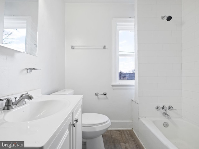 full bathroom featuring tiled shower / bath combo, wood-type flooring, vanity, and toilet