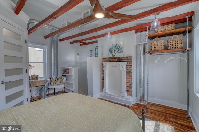 bedroom with beamed ceiling and dark hardwood / wood-style floors