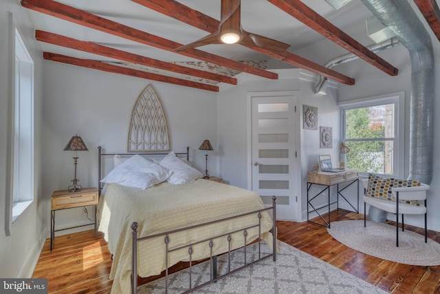 bedroom featuring hardwood / wood-style floors and beam ceiling