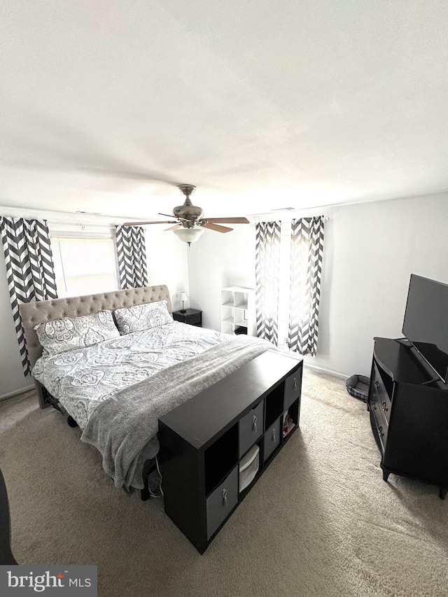 bedroom with light colored carpet and a ceiling fan