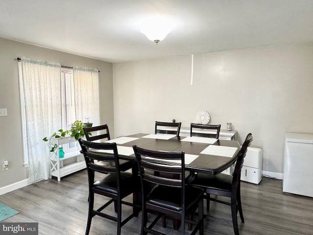 dining room featuring wood finished floors and baseboards