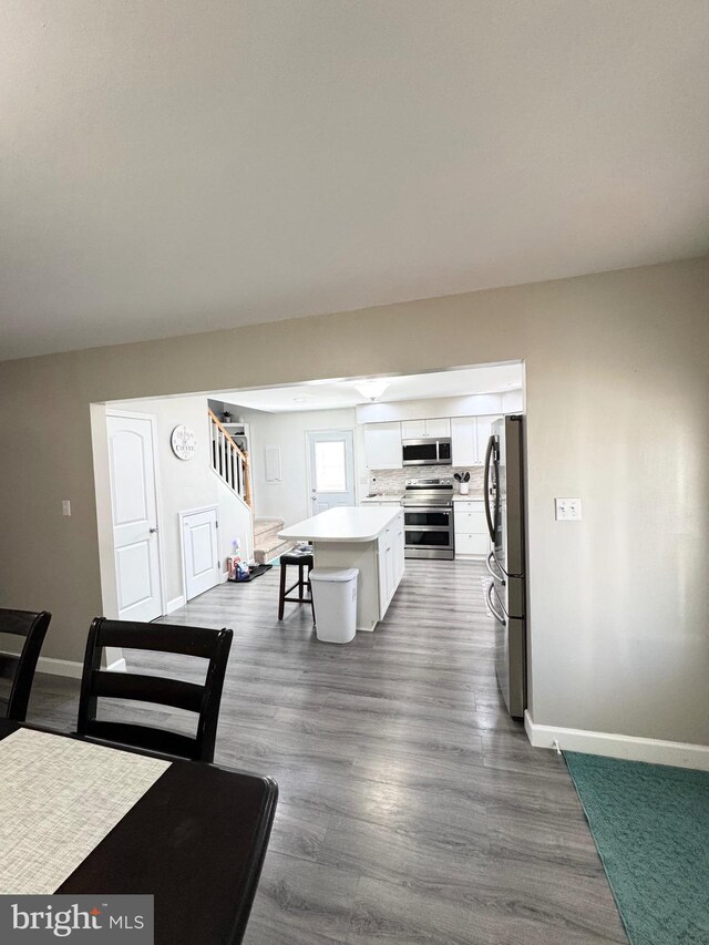 dining room featuring stairway, baseboards, and dark wood-style flooring