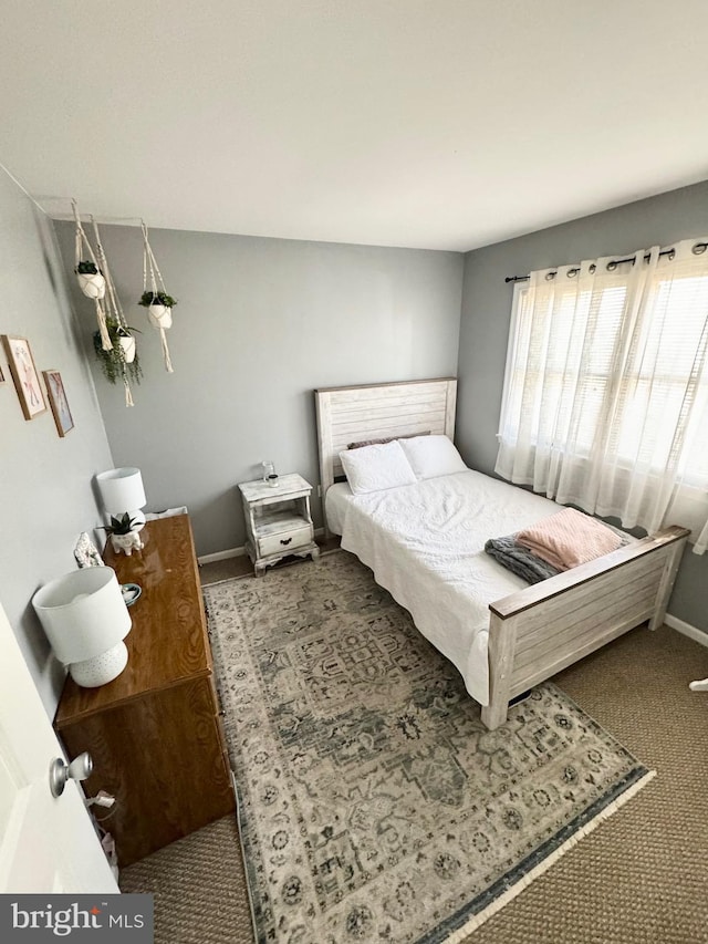 bedroom featuring baseboards and carpet