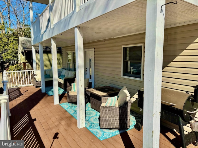 wooden terrace with an outdoor living space