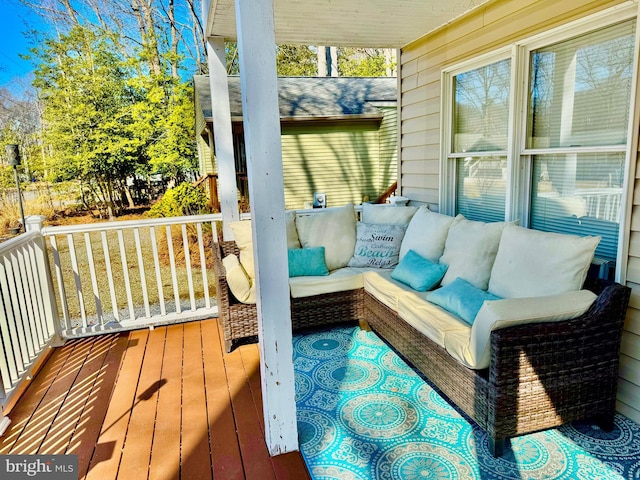 wooden terrace with an outdoor living space