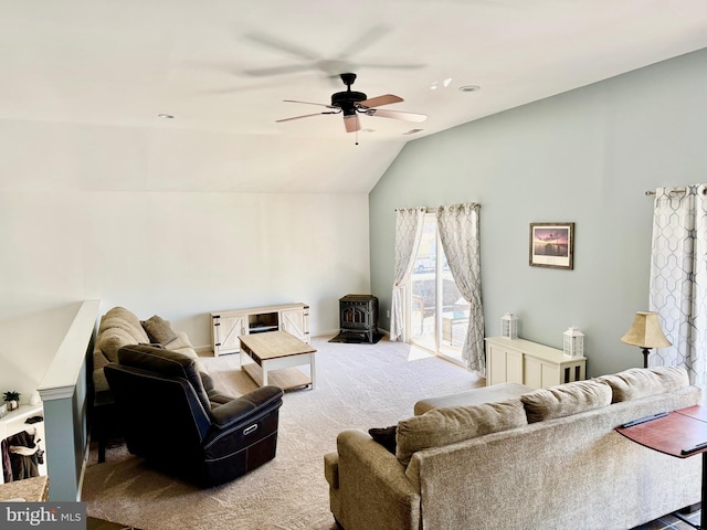 carpeted living area with lofted ceiling, a wood stove, and ceiling fan