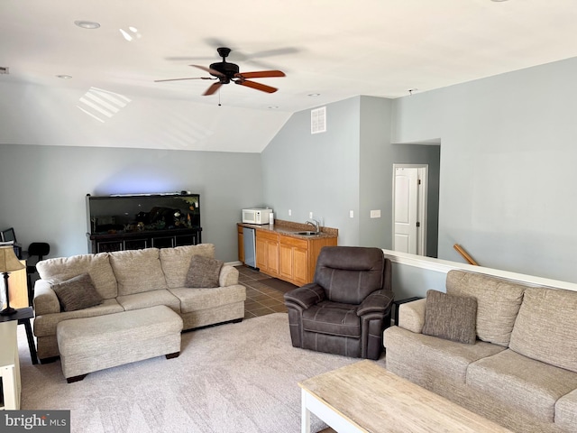 carpeted living room with visible vents, ceiling fan, tile patterned flooring, vaulted ceiling, and a sink