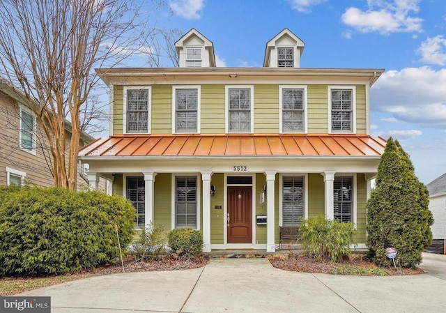 view of front facade featuring a standing seam roof, covered porch, and metal roof