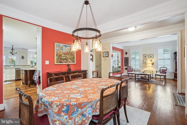 dining room featuring crown molding, baseboards, and wood-type flooring