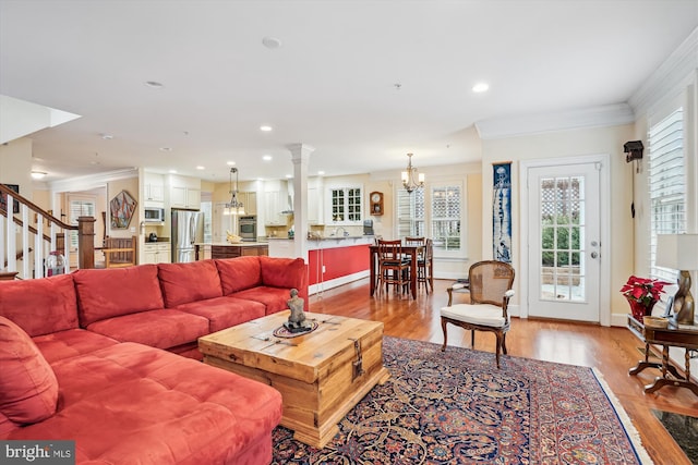 living area with crown molding, recessed lighting, light wood-type flooring, and baseboards