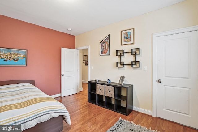 bedroom with baseboards and wood finished floors