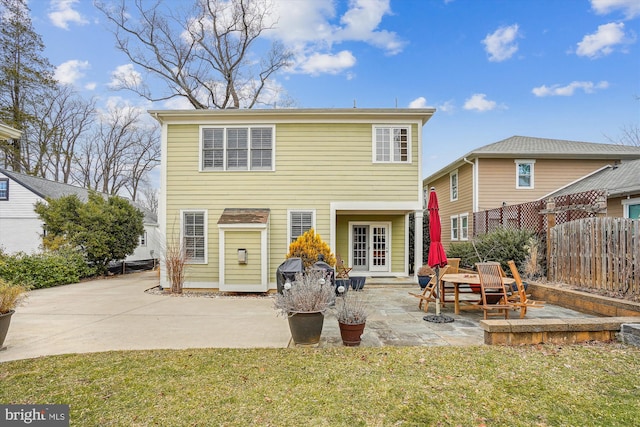 back of property featuring a patio area, fence, and a lawn