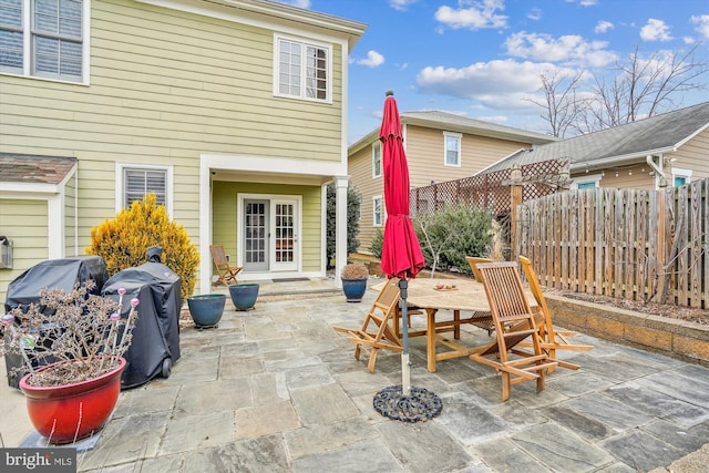 view of patio / terrace with area for grilling, outdoor dining area, french doors, and fence