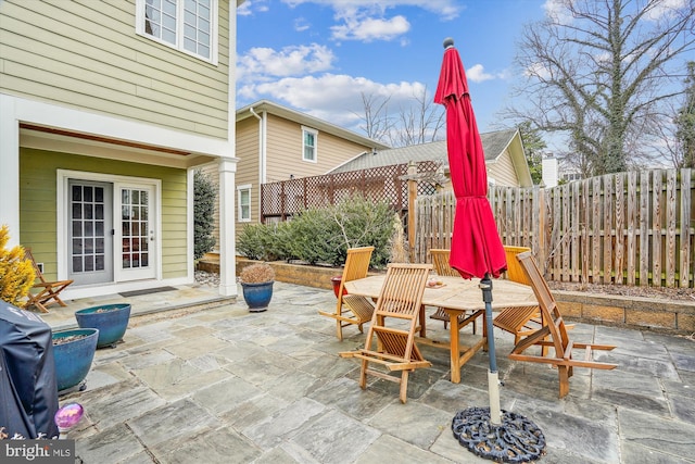 view of patio with french doors, area for grilling, outdoor dining space, and fence