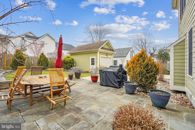 view of patio / terrace with outdoor dining area, an outbuilding, a grill, and fence