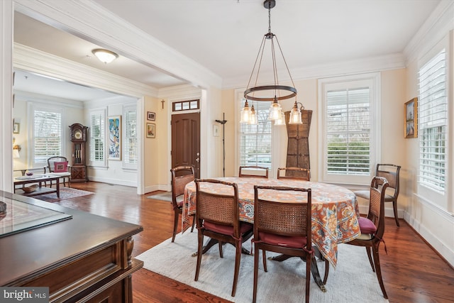 dining space with crown molding, baseboards, and dark wood-style flooring