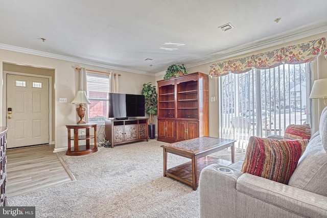 living room featuring ornamental molding, visible vents, light carpet, and baseboards