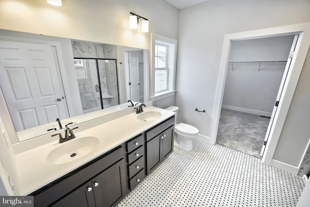 bathroom featuring toilet, an enclosed shower, and vanity