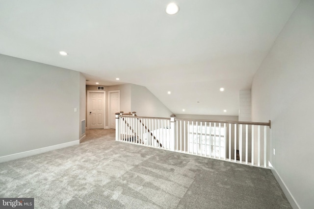 empty room with light carpet and vaulted ceiling