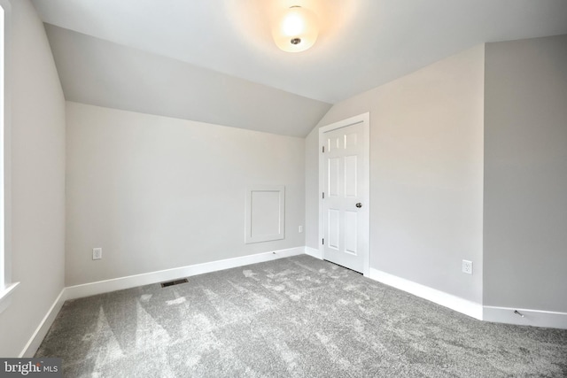 bonus room with vaulted ceiling and carpet