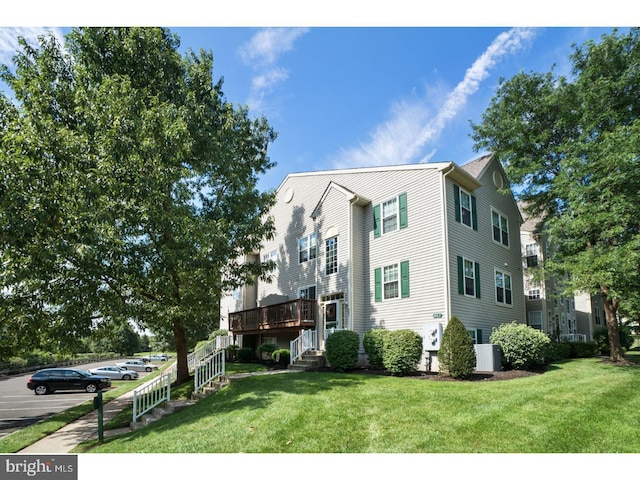 view of front facade featuring a deck, central AC, and a front lawn