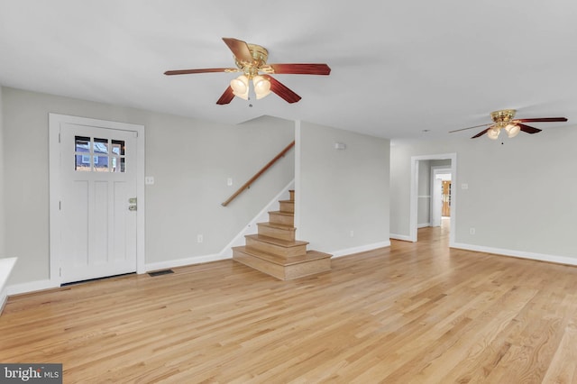 foyer featuring stairway, light wood-type flooring, visible vents, and baseboards