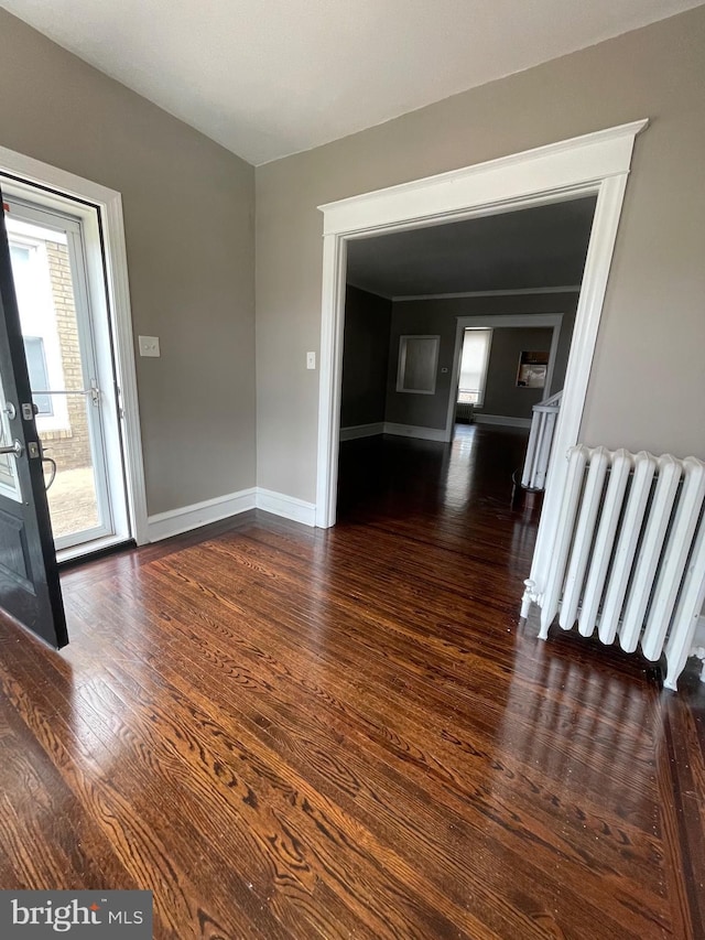 interior space with radiator and dark hardwood / wood-style flooring