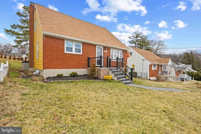 bungalow featuring brick siding, fence, a front lawn, and roof with shingles