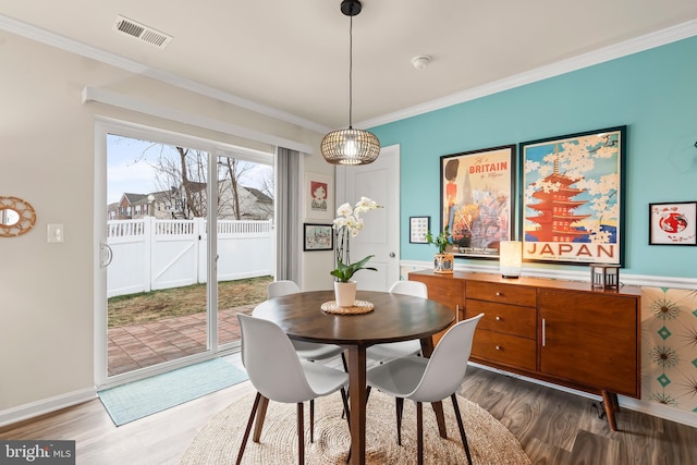 dining room with ornamental molding and hardwood / wood-style flooring