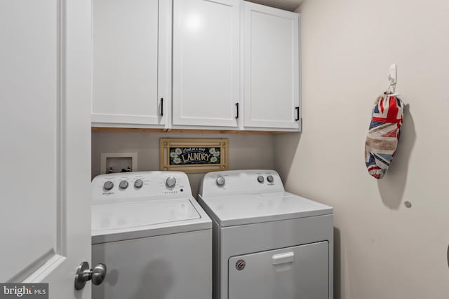 clothes washing area with independent washer and dryer and cabinets