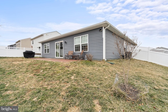 rear view of house featuring a patio and a yard