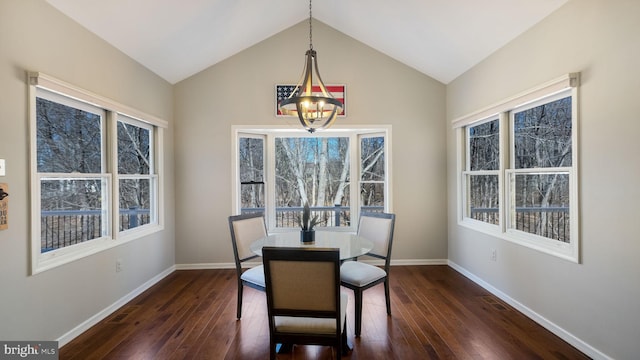 dining area featuring dark wood finished floors, baseboards, an inviting chandelier, and vaulted ceiling