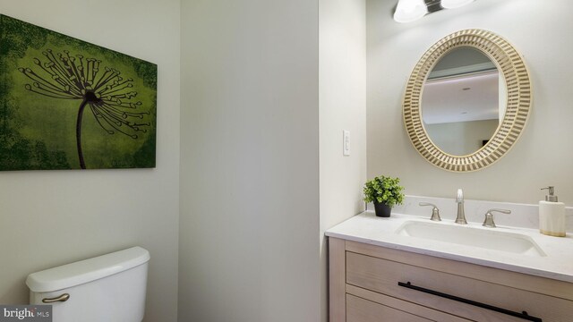 half bath featuring toilet and vanity