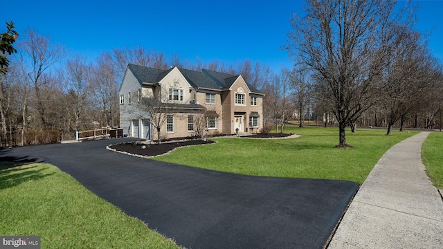 view of front facade featuring aphalt driveway, a front lawn, and a garage