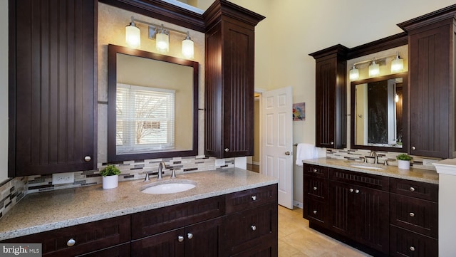 full bath featuring a sink, decorative backsplash, two vanities, and tile patterned flooring