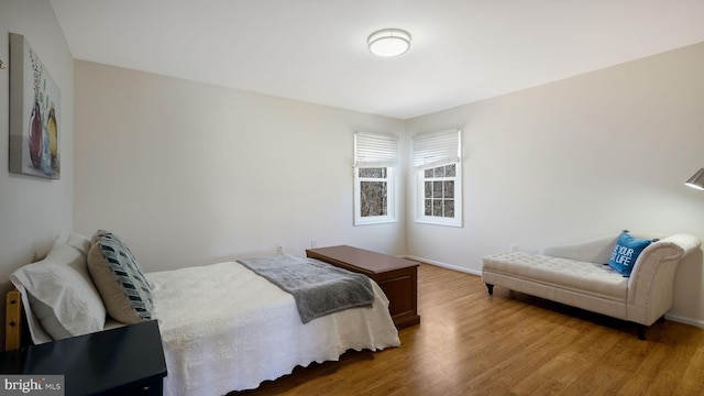 bedroom with baseboards and wood finished floors