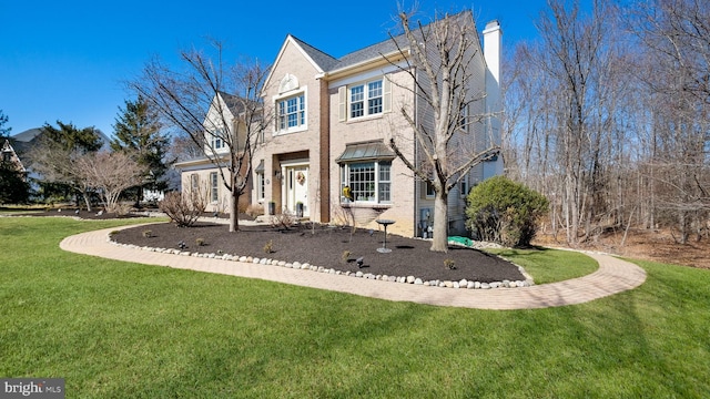 traditional-style house with a front lawn, brick siding, and a chimney