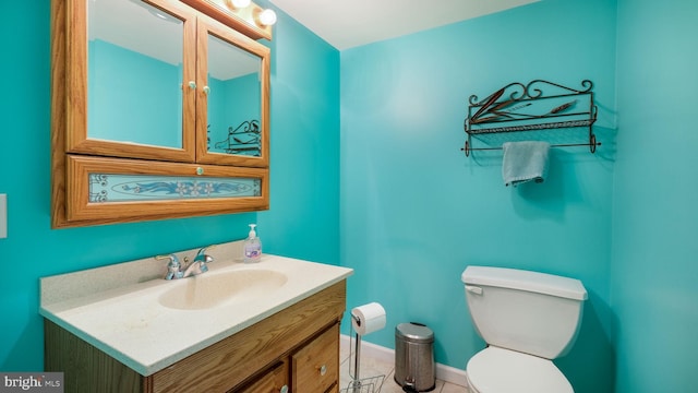 bathroom featuring baseboards, toilet, and vanity