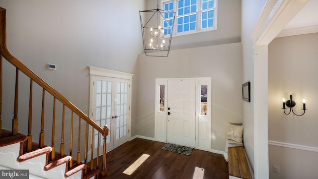 entryway featuring a towering ceiling, french doors, dark wood-style floors, and stairs