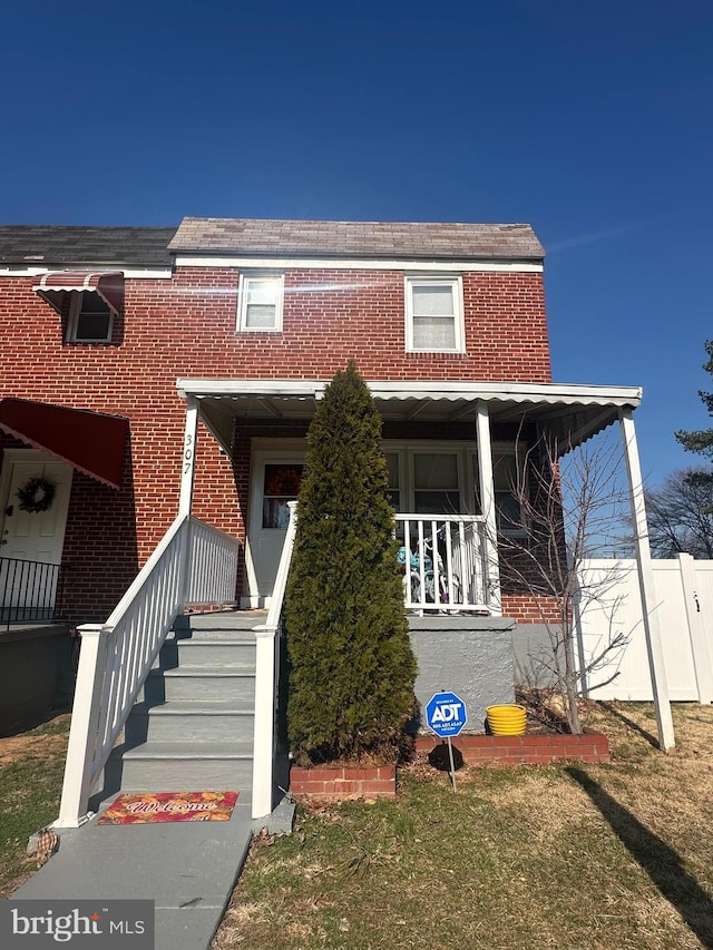 view of front of home with brick siding and covered porch