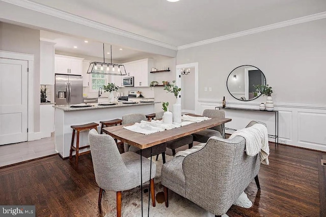 dining room featuring sink, dark wood-type flooring, and crown molding