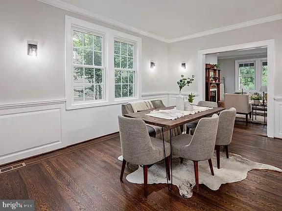 dining room with dark hardwood / wood-style flooring and ornamental molding