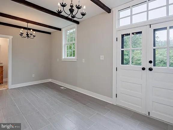 entryway featuring french doors, beamed ceiling, and an inviting chandelier