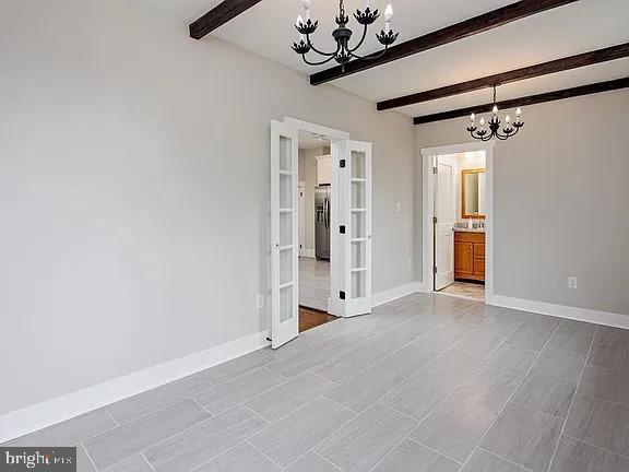 interior space with beamed ceiling and an inviting chandelier