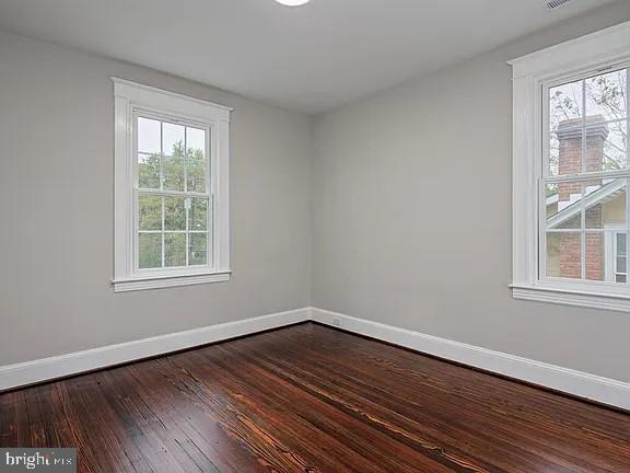 unfurnished room featuring wood-type flooring and a healthy amount of sunlight