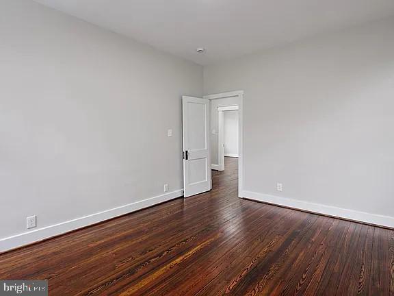 unfurnished room featuring dark hardwood / wood-style flooring