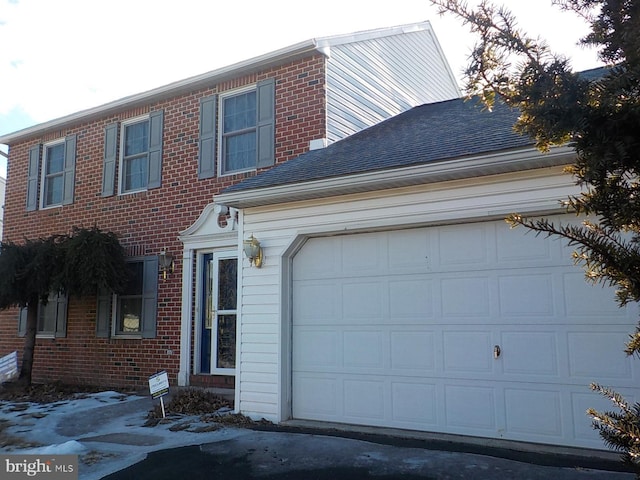 view of front of home featuring a garage, brick siding, and a shingled roof